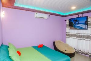 um quarto com uma cama e uma televisão na parede em Feeling tip'sea rooftop villa em Mirissa