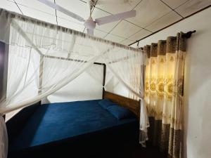 a bedroom with a bed with a mosquito net at Pahasara Villa in Mirissa