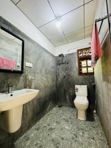 a bathroom with a sink and a toilet at Pahasara Villa in Mirissa