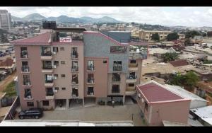 a large building with a parking lot in a city at Résidence l'appart in Yaoundé