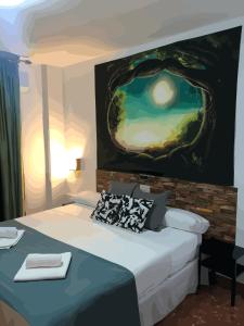 Habitación con cama y pintura en la pared en Hotel Al-Ándalus Peal, en Cazorla Comarca, en Peal de Becerro