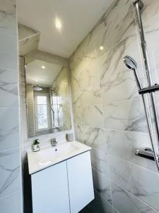 a white bathroom with a sink and a shower at Le Gentil Rooftop in Gentilly