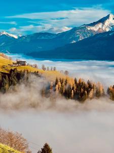 a view of a foggy valley with mountains at Hochleiten-Gut in Niedernsill