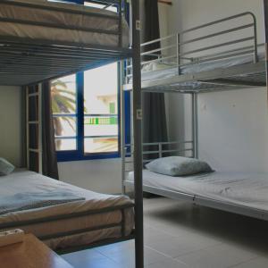 two bunk beds in a room with a window at Famara Home stay in Famara