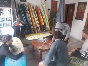 a group of people sitting around a table with surfboards at Famara Home stay in Famara