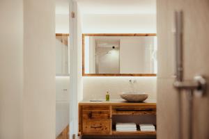 a bathroom with a sink and a mirror at Villa Flora Mountain Lodges in San Cassiano +51 photos