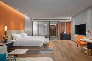 西安市にあるvoco Xi'an Qindu Legend, an IHG Hotelのベッドルーム1室(ベッド1台付)、リビングルームが備わります。