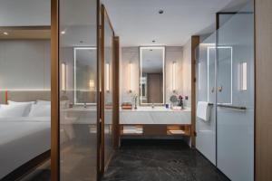 voco Xi'an Qindu Legend, an IHG Hotel في شيان: حمام به سرير وحوض استحمام ومغسلة