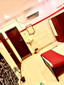 a bathroom with a red bed and a toilet at HOTEL SITA GRAND in Shamshabad