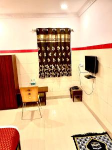 uma sala de estar com televisão e uma mesa num quarto em HOTEL SITA GRAND em Shamshabad