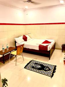 a bedroom with a bed and a table and a chair at HOTEL SITA GRAND in Shamshabad
