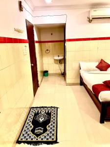 a room with a bathroom with a bed and a rug at HOTEL SITA GRAND in Shamshabad
