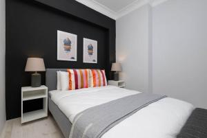 - une chambre avec un lit blanc et un mur noir dans l'établissement Cosy Urban 2-Bedroom Apartment, à Istanbul