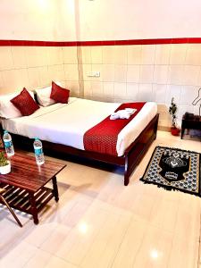 a bedroom with a large bed and a table at HOTEL SITA GRAND in Shamshabad