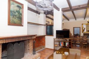 a living room with a fireplace and a dining room at Finca Los Majadales in Almodóvar del Río