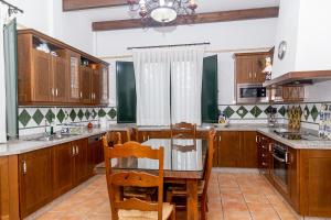a kitchen with wooden cabinets and a table and chairs at Finca Los Majadales in Almodóvar del Río