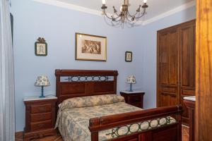 una camera con letto, mobili in legno e lampadario a braccio di Finca Los Majadales ad Almodóvar del Río