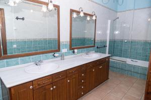 un bagno con due lavandini e un grande specchio di Finca Los Majadales ad Almodóvar del Río Altre 17 foto