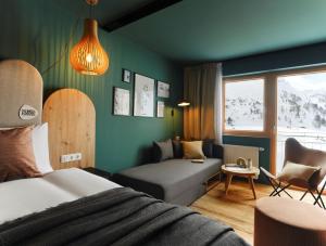 オーバータウエルンにあるOBERTAUERN PLACESHOTEL by Valamarのベッドとソファ付きのホテルルーム