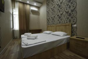 a bedroom with two beds with white towels on them at Family Hotel Avlabar in Tbilisi City