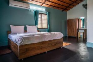 sypialnia z dużym łóżkiem z różowymi poduszkami w obiekcie LEO COMFORTS RIVER SIDE w mieście Hampi
