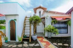 una casa blanca con una escalera y macetas en Feeling tip'sea rooftop villa, en Mirissa