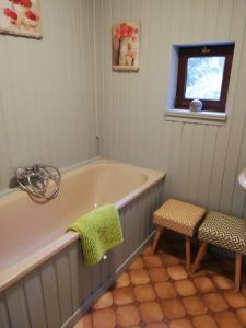 ein Bad mit einer Badewanne, einem Stuhl und einem Fenster in der Unterkunft Lesse en Ciel vous accueille avec plaisir . in Houyet