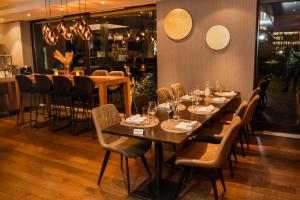 une salle à manger avec des tables et des chaises ainsi qu'un bar dans l'établissement Hotel Belair, à Wallisellen