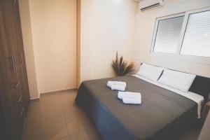 1 dormitorio con 1 cama con 2 toallas en Mardel_seaside_selinia, en Salamina