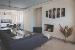 a living room with a black couch and a table at Mardel_seaside_selinia in Salamina