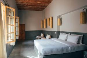 um quarto com uma cama, uma mesa e uma janela em Riad no37 em Marraquexe