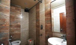 ein Badezimmer mit einem Waschbecken, einem WC und einem Spiegel in der Unterkunft FabHotel Madurai in Udaipur
