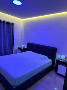 sypialnia z dużym łóżkiem z niebieskim oświetleniem w obiekcie Appartement La Croisette w mieście Nabul