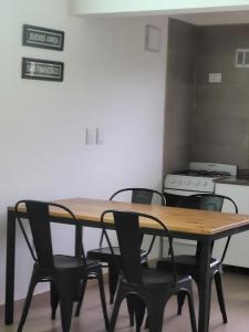 a wooden table and chairs in a room with a stove at El montañes in San Carlos de Bariloche