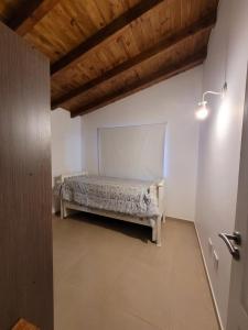 a bedroom with a bed and a wooden ceiling at El montañes in San Carlos de Bariloche