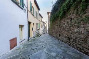 un callejón en una ciudad con una pared de piedra en Medieval Cottage, en Monte San Savino
