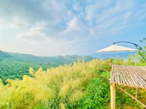 Làng Song Ca的住宿－Khu du lịch sinh thái Cỏ Lau Village，山顶上的白色遮阳伞