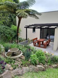 a garden with a picnic table and a fountain at Serenity Place Garden View in Durban
