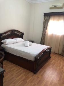 ein Schlafzimmer mit einem großen Bett mit weißer Bettwäsche und einem Fenster in der Unterkunft Magawish Villa hurghada in Hurghada