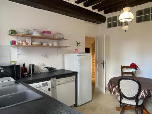 a kitchen with a white refrigerator and a table at Gite 5 personnes SOLOGNE in Hargeville