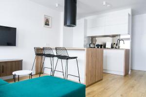 a kitchen with two stools and a counter in a room at Apartamenty Parkowa 9 in Lesko