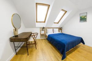 a bedroom with a bed and a desk and a mirror at Apartamenty Parkowa 9 in Lesko