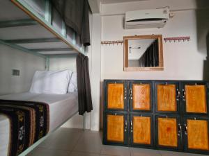 Dormitorio pequeño con cama y espejo en Lala Salama Backpacker en Teluk Nara