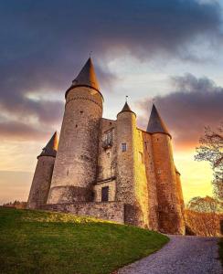 ein Schloss mit Türmen auf einem Grasfeld in der Unterkunft Lesse en Ciel vous accueille avec plaisir . in Houyet