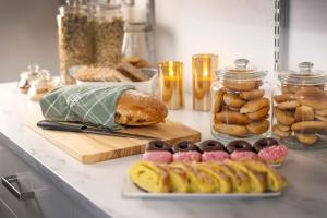 a counter with bread and pastries and jars of food at Hotell Skövde in Skövde