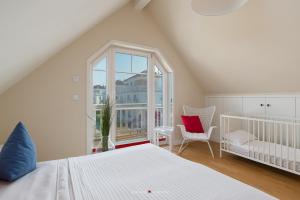 a bedroom with a white bed and a window at Strandhaus La Vela in Olpenitz