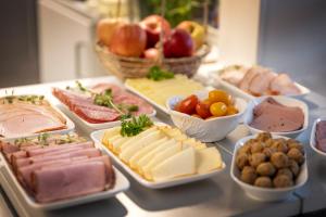 a table with different types of cheeses and other foods at Hotell Skövde in Skövde +20 photos