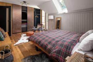 a bedroom with a bed with a plaid blanket at Peaceful, Cozy Designer Mountain Studio in Harrachov +2 photos