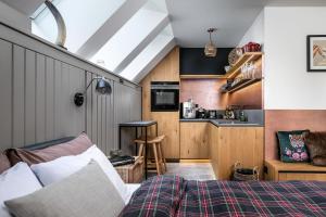 a room with a bed and a small kitchen at Peaceful, Cozy Designer Mountain Studio in Harrachov