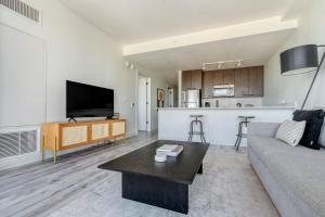 a living room with a couch and a table and a kitchen at Downtown 1br w gym wd near restaurants ATX-230 in Austin